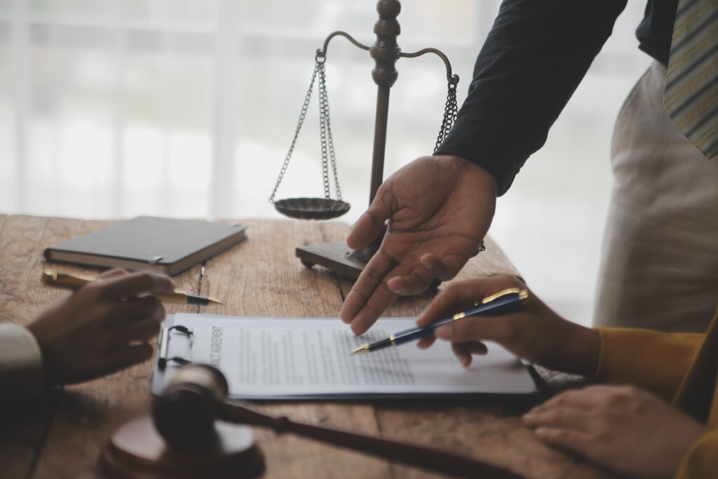 Business professionals and lawyers reviewing contract documents.